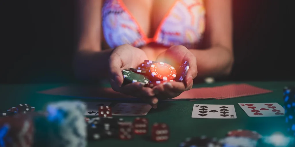 Mujer en bikini sosteniendo fichas de póker sobre una mesa de juego, con cartas y dados visibles, ilustrando una partida de strip póker.