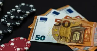 Fichas de casino junto a billetes de 50 euros, que representan métodos de pago populares y transacciones en casinos en línea.